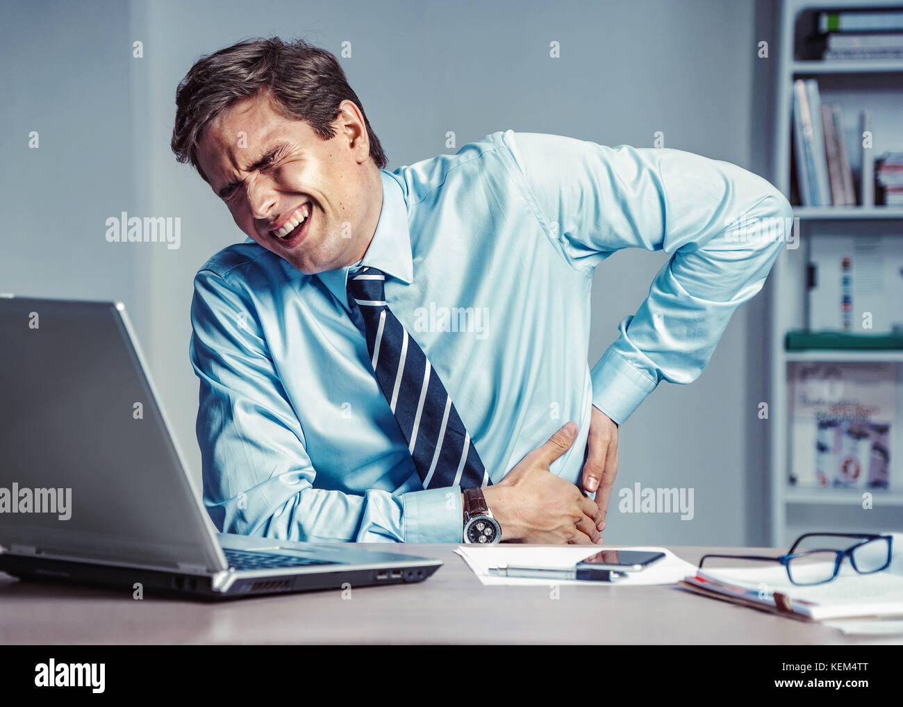 Employé souffre d'une douleur à l'arrière. photo d'un homme travaillant au bureau. concept médical. Banque D'Images