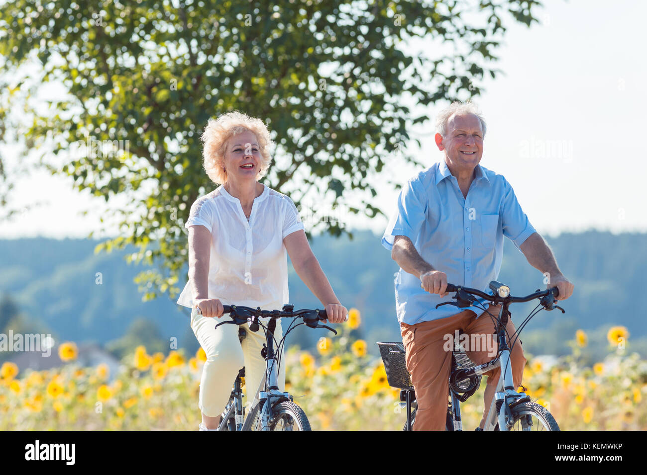 Personnes âgées actives couple riding bicycles ensemble dans le countrysid Banque D'Images