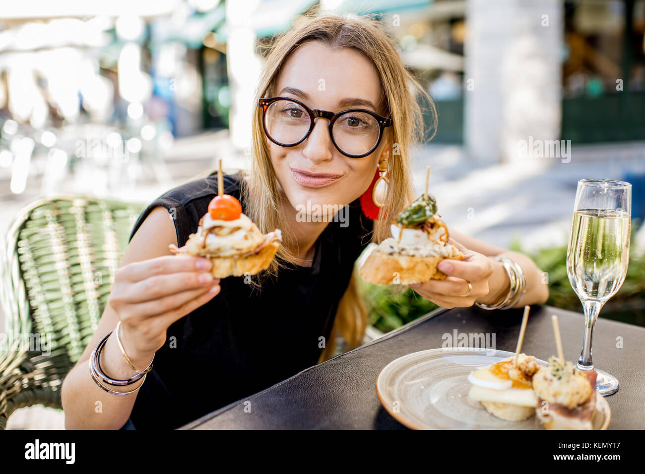 Woman eating espagnol pinchos au bar en plein air Banque D'Images