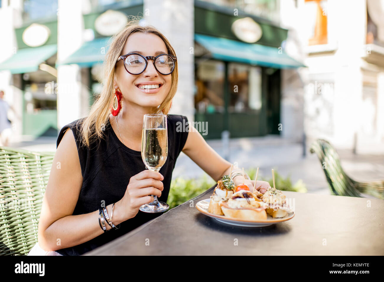 Woman eating espagnol pinchos au bar en plein air Banque D'Images