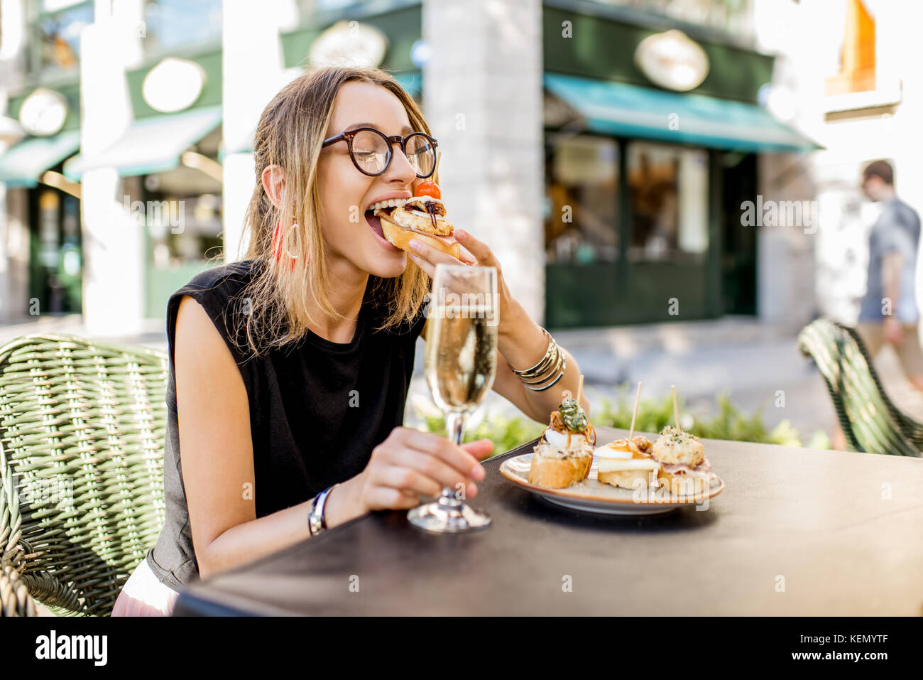Woman eating espagnol pinchos au bar en plein air Banque D'Images
