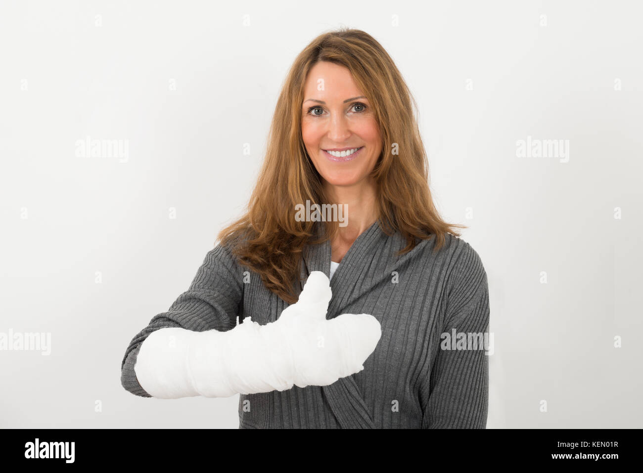 Portrait of happy young woman avec fracture de la main à bandage Banque D'Images