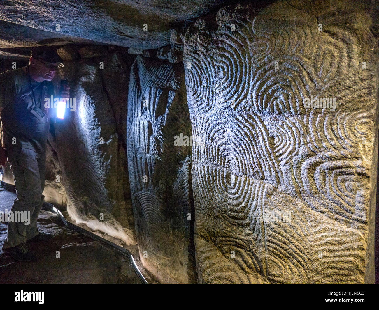 Visite guidée aux flambeaux GAVRINIS GUIDE de sculptures en pierre de l'intérieur de la texture, la France Bretagne cairn préhistorique, dolmen, tombe en pierre sèche, avec le célèbre et symbolique de l'âge de pierre mystérieux sculptures. Un des exemples les plus remarquables de la première apparition de l'architecture dans le monde occidental. Cairn de Gavrinis Cale de Penn-Lannic Sagemor larmor baden, Bretagne France (Megalithes du Morbihan) Banque D'Images