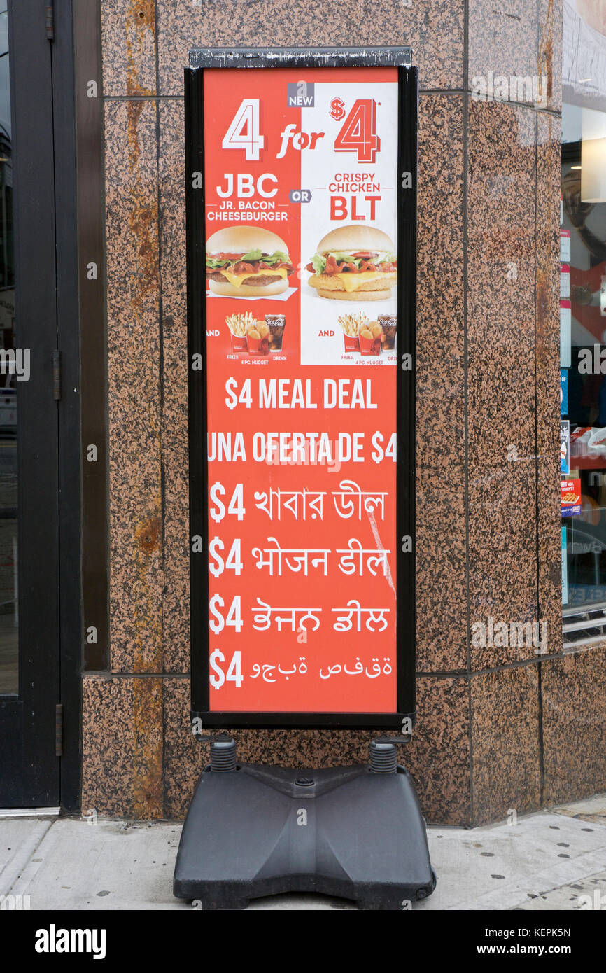 Un signe en 6 langues (de haut en bas : Anglais, Espagnol, Français, Indien, le punjabi et l'ourdou) à l'extérieur d'une Wendy's sur Broadway à Jackson Heights, Queens, New York. Banque D'Images