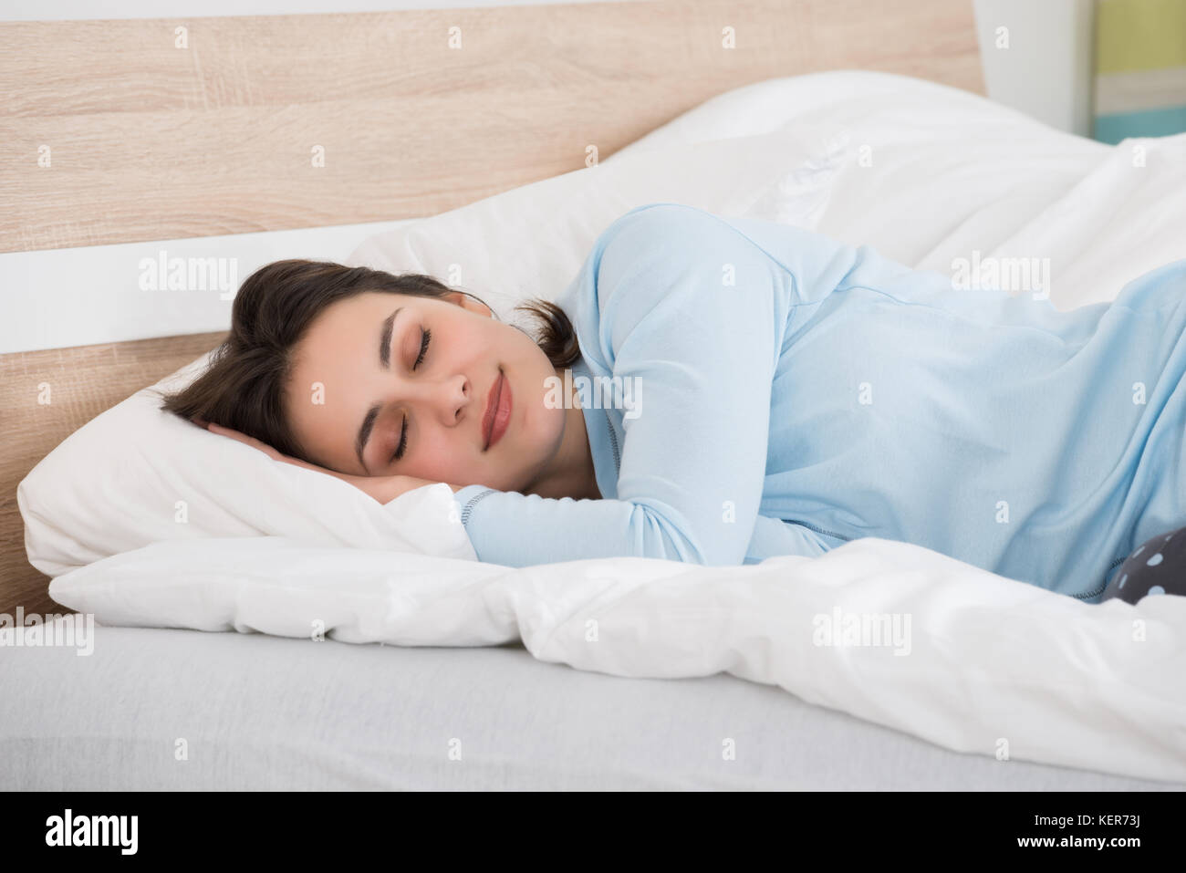 Photo de jeune femme dormir sur le lit Banque D'Images