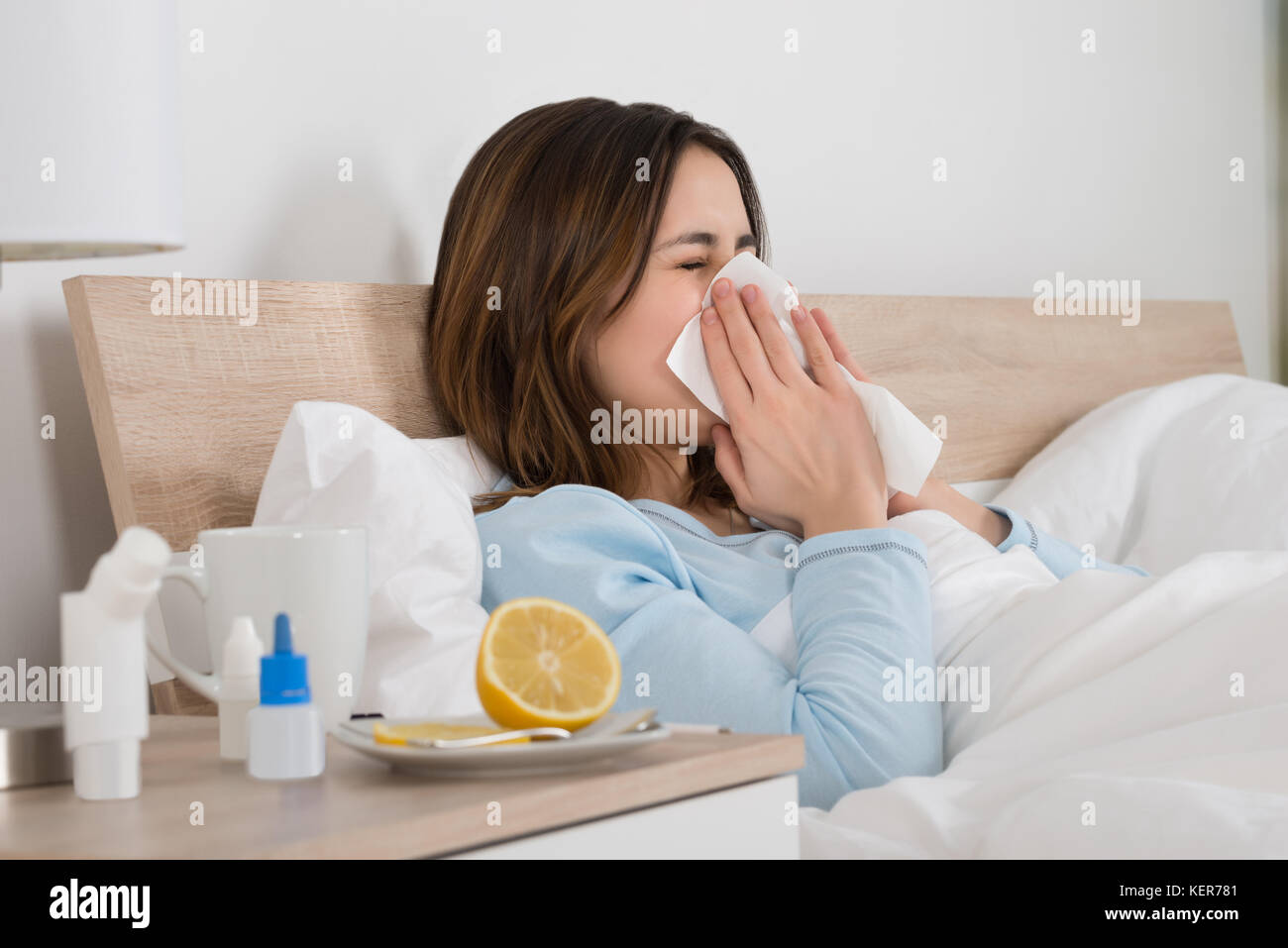 Jeune femme infectée par soufflage froid son nez dans un mouchoir Banque D'Images