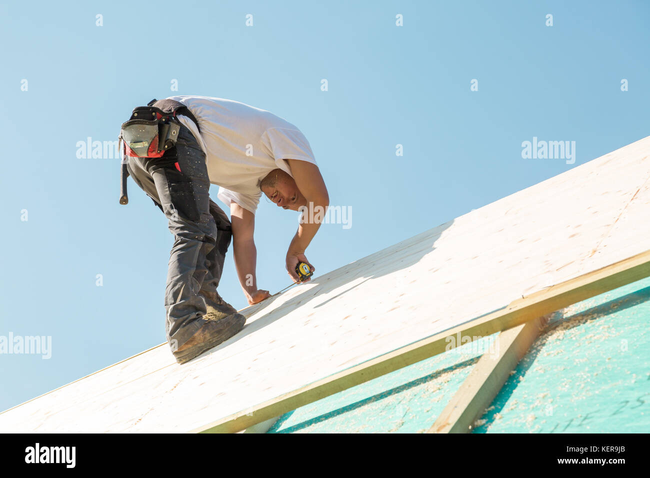 Builder au travail avec un toit en bois de construction. Banque D'Images