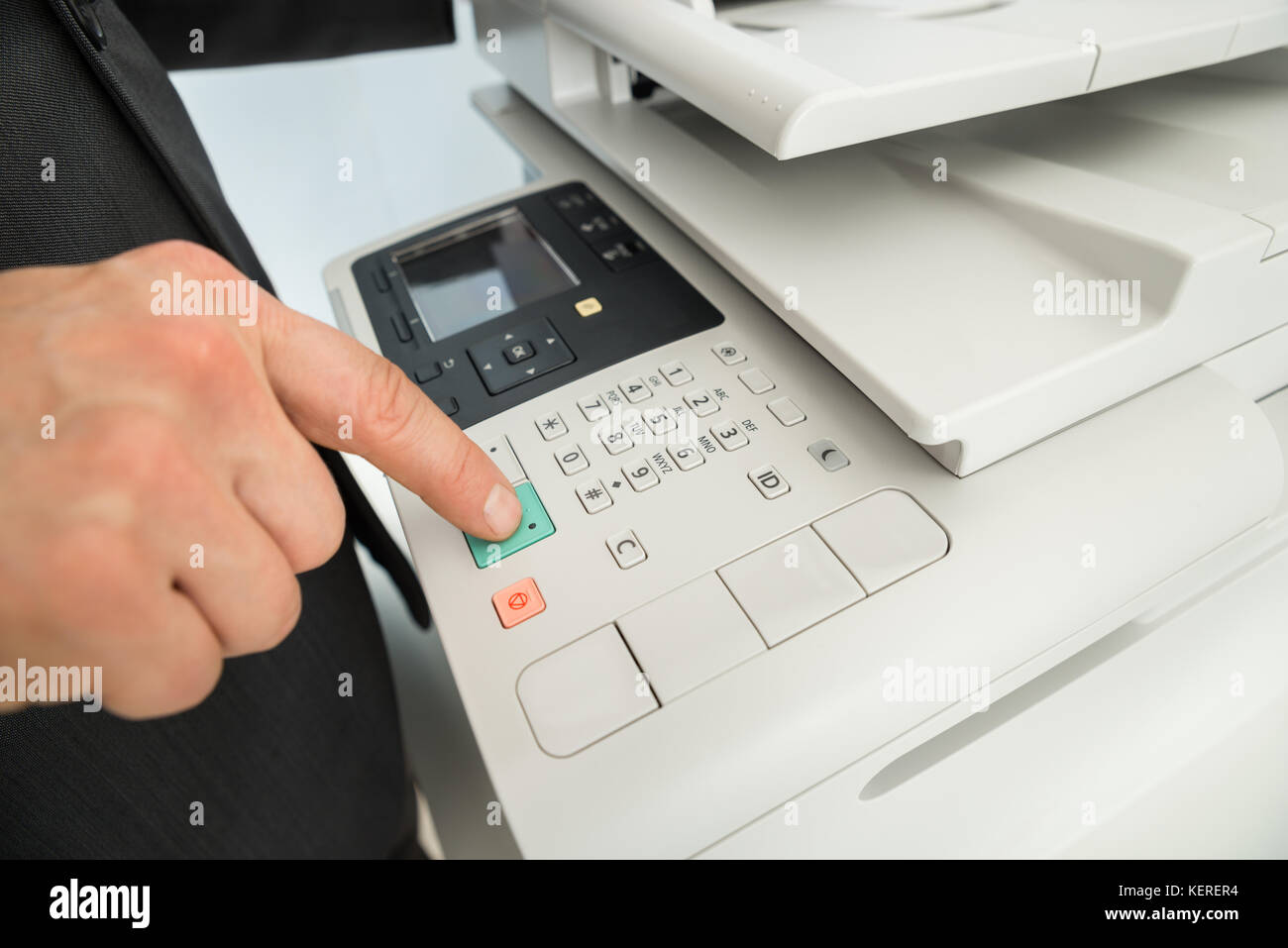 Close-up of young part en appuyant sur le bouton de l'imprimante dans office Banque D'Images