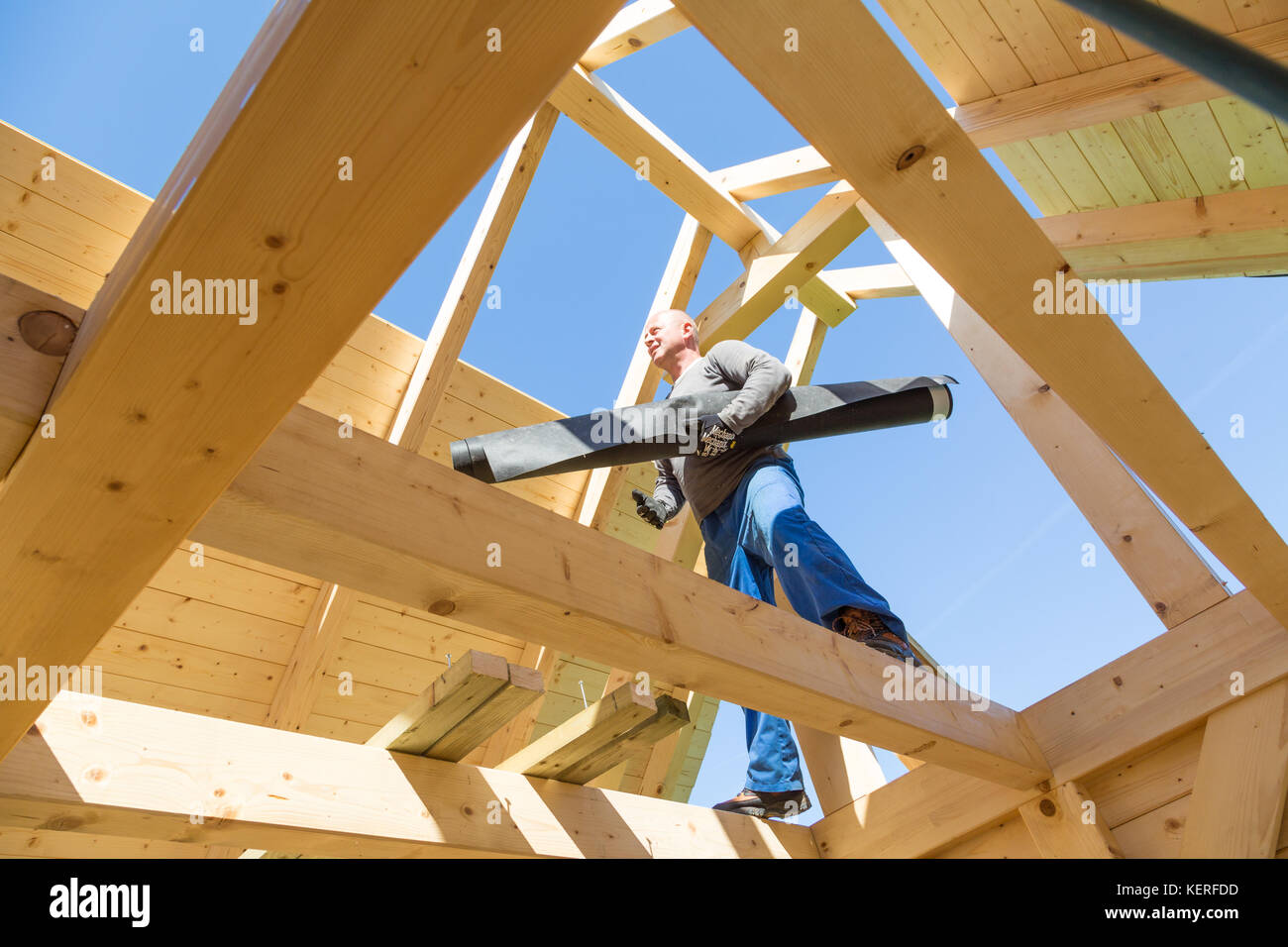 Builder au travail avec un toit en bois de construction. Banque D'Images