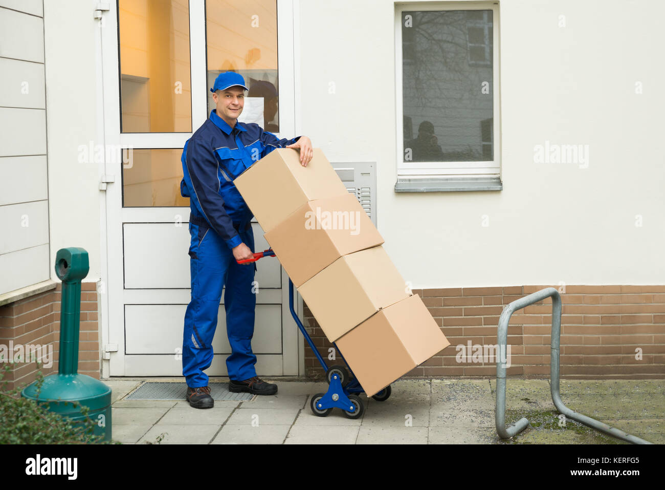 Mature man holding boxes sur un camion de main Banque D'Images