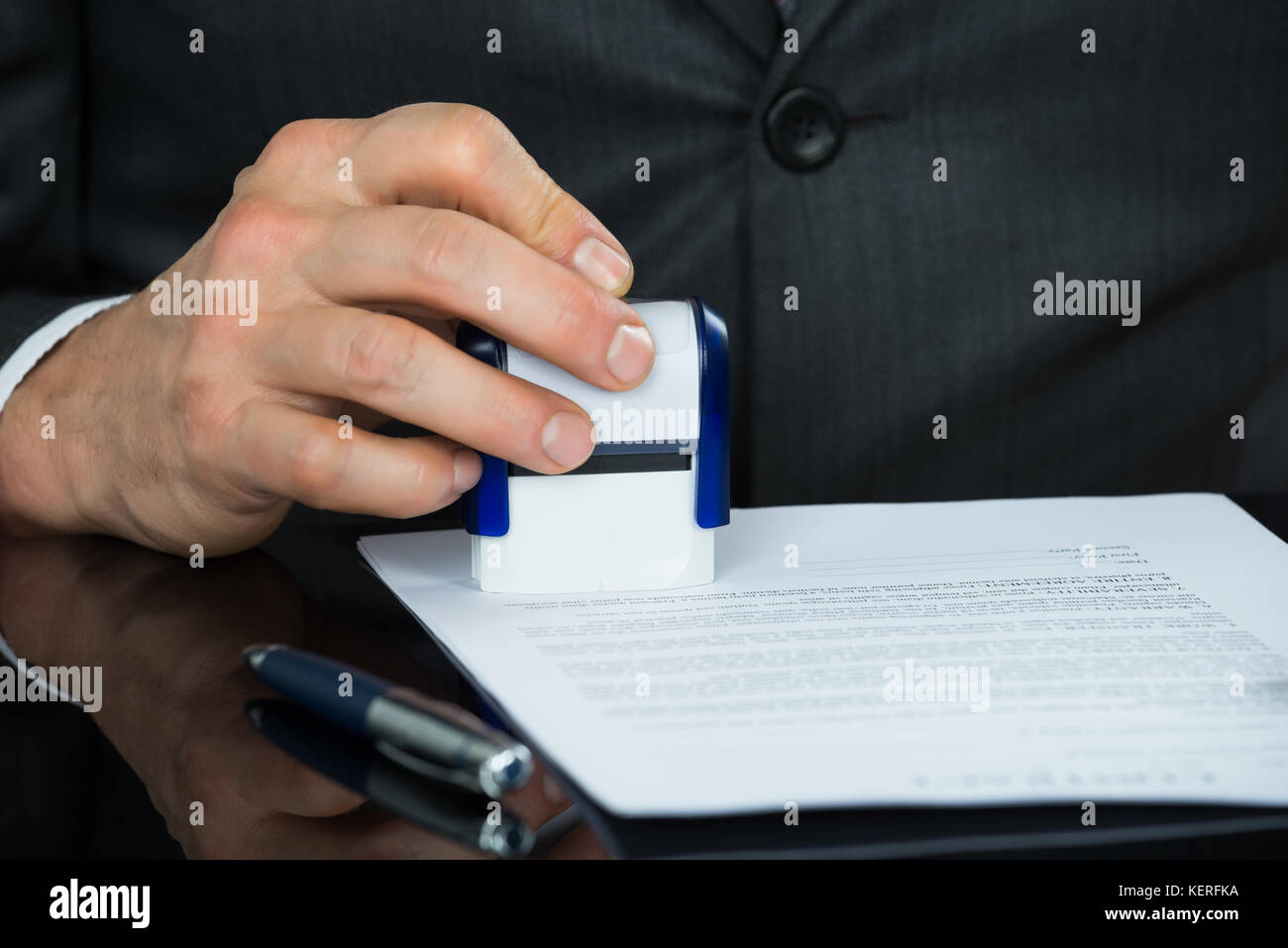 Close-up of Businessman Stamping Document à 24 Banque D'Images