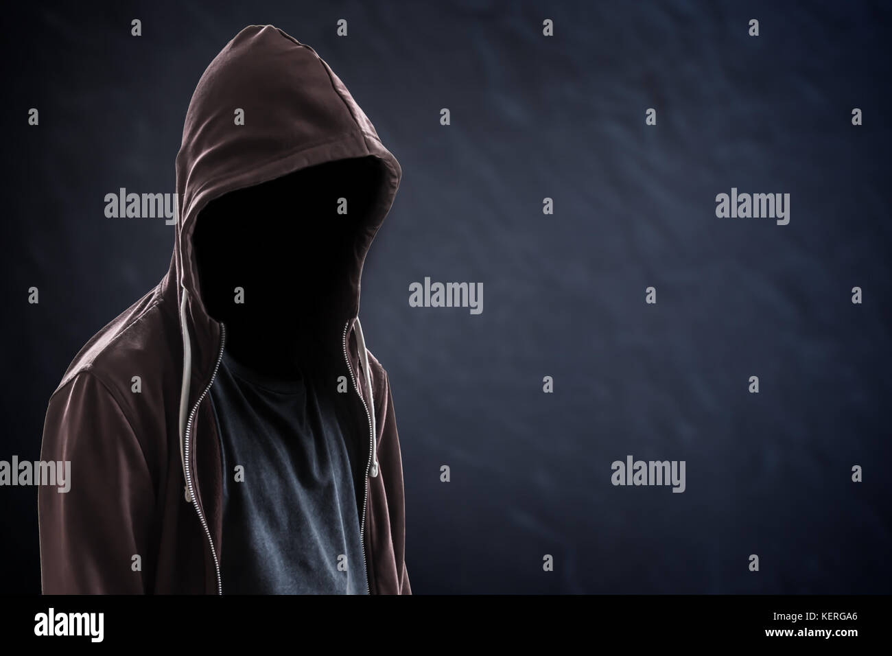 Silhouette d'homme avec une capuche et le visage dans le noir, fond noir avec copie espace, criminel ou concept hacker Banque D'Images