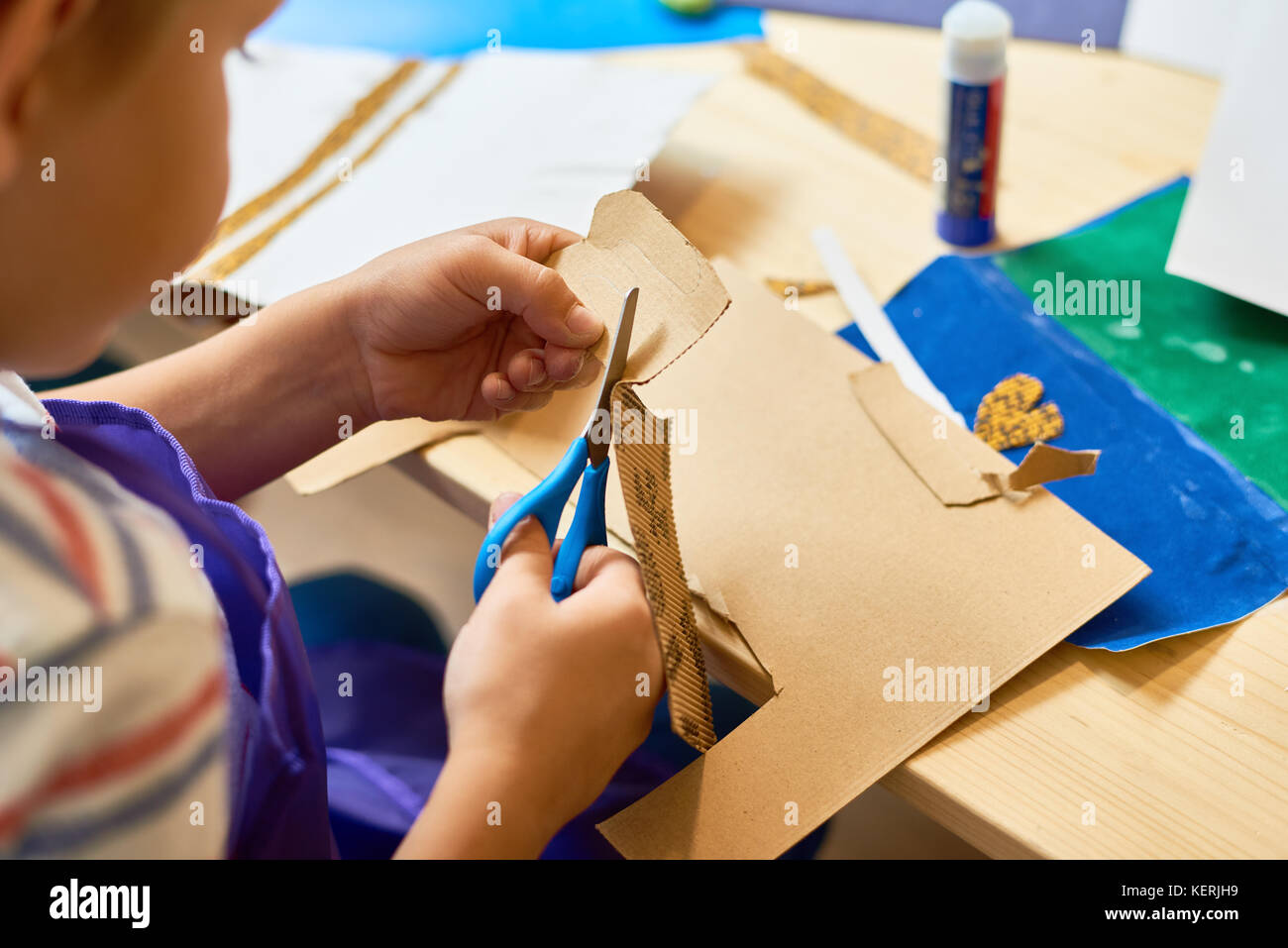 Petit garçon dans un cours d'artisanat papier coupe Banque D'Images