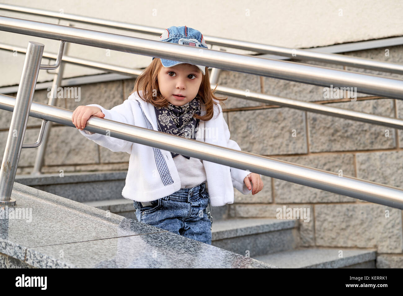 Fille enfant modèle hip hop sur l'escalier extérieur.children's street fashion denim Banque D'Images