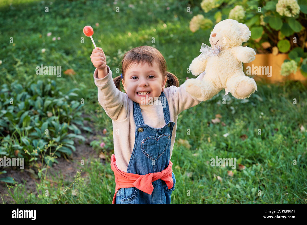 Funny little girl sauter de joie.un jeune enfant en denim bleu de travail Banque D'Images