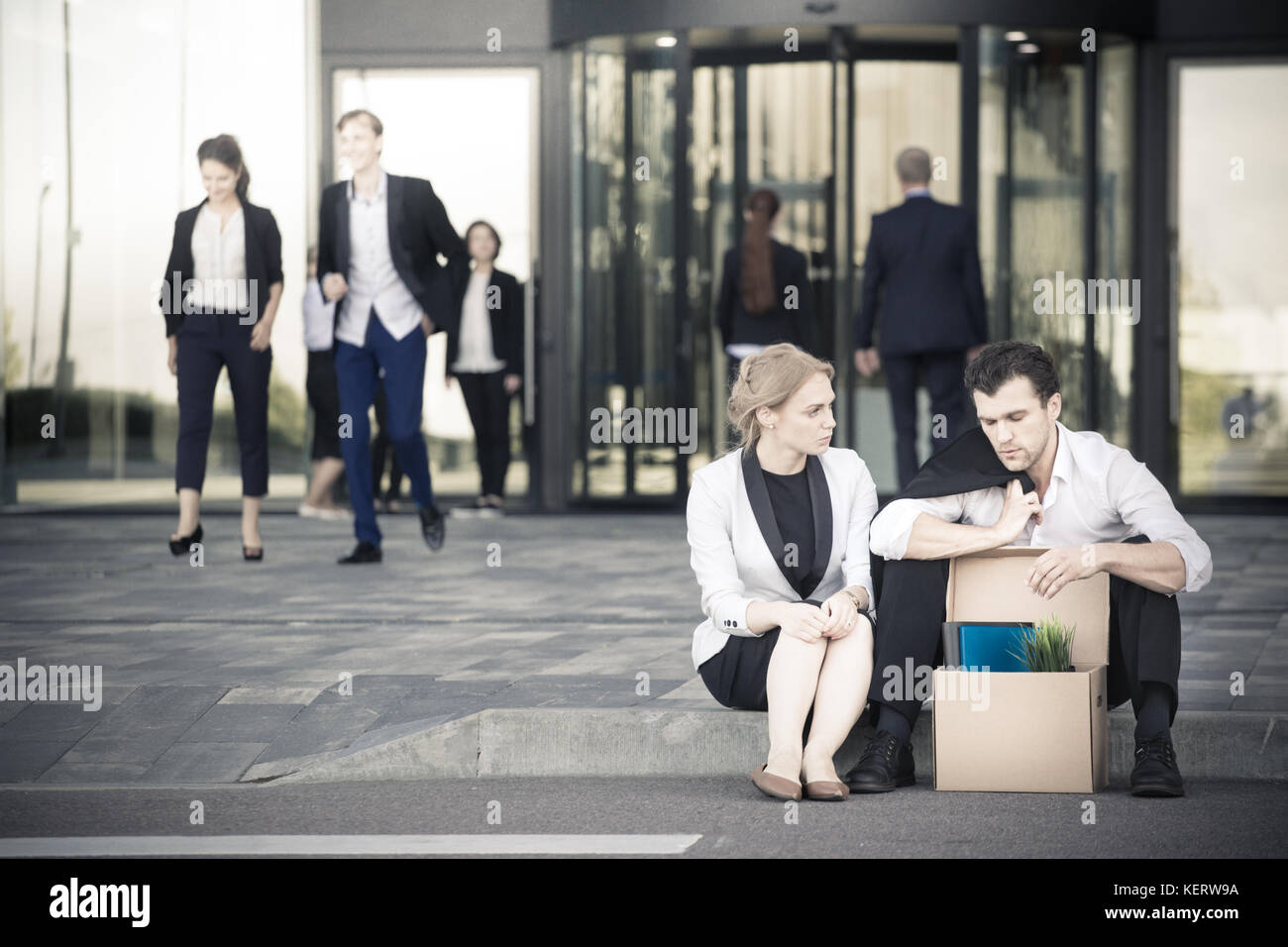 Tiré business man sitting frustré et contrarié dans la rue près de l'immeuble de bureaux de fort de ses affaires. Il a perdu travail. business woman un confort Banque D'Images