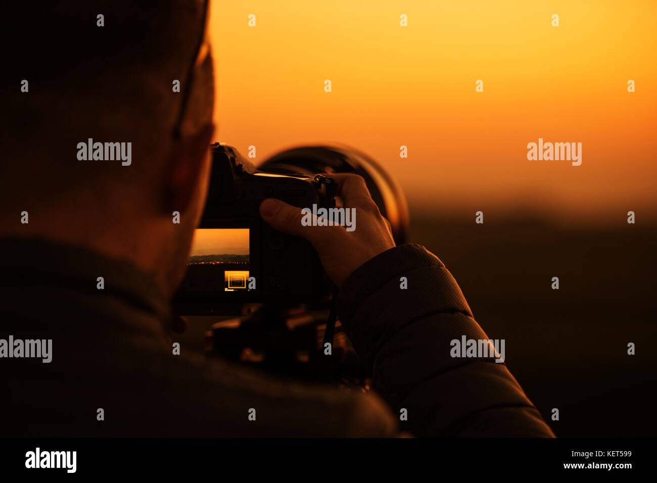 La photographie et vidéographie dslr concept. appareil photo numérique moderne avec téléobjectif. photographe au travail pendant le coucher du soleil magnifique. Banque D'Images