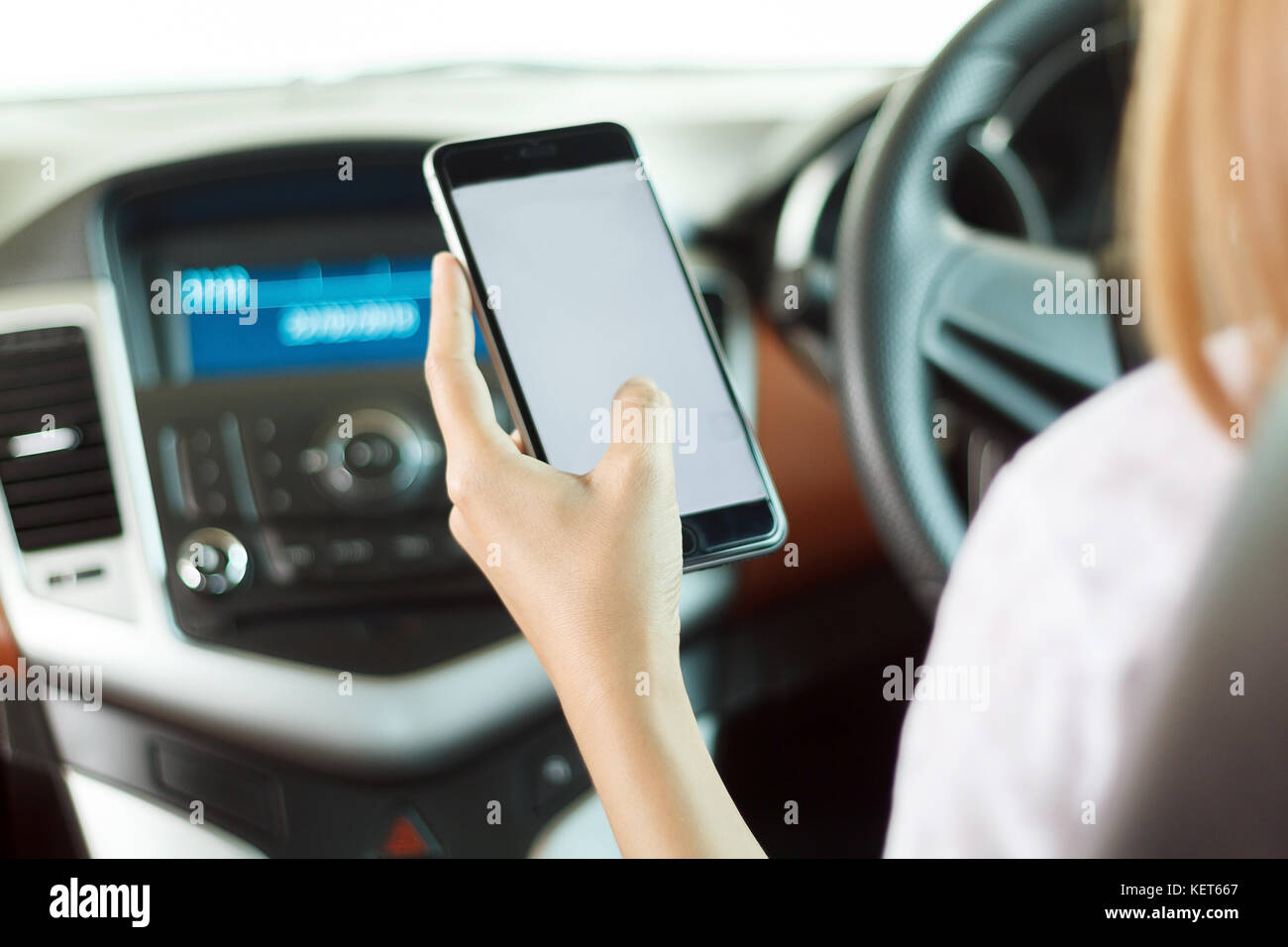 Asiatique femme holding phone in car Banque D'Images