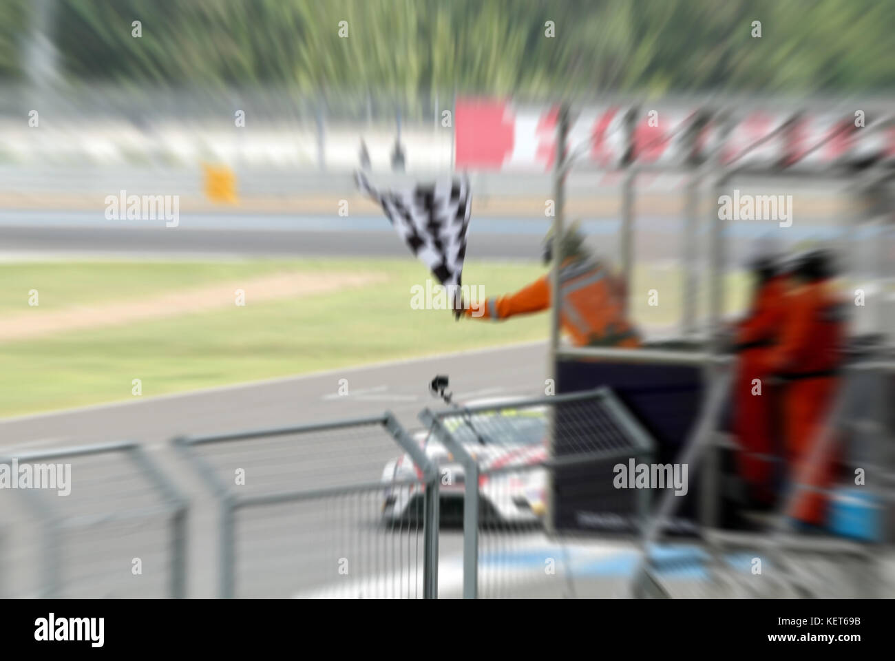 De floue et agiter le drapeau sur le stand pour la course à la ligne d'arrivée et raceway Banque D'Images