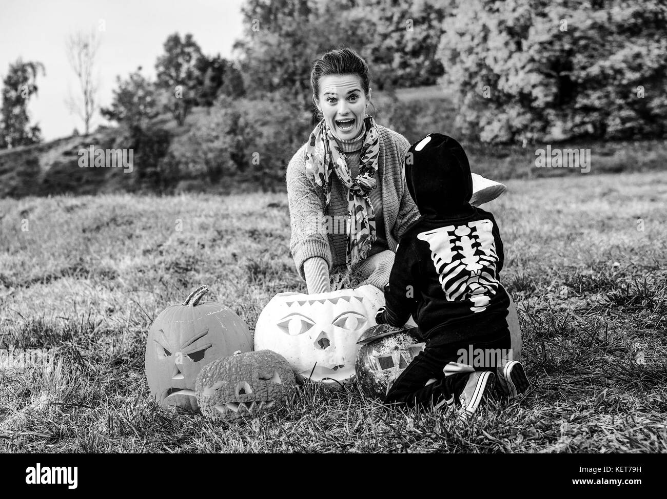 Trick or Treat. jeune mère et fille à l'halloween dans le parc et jouent avec la citrouille Jack O'lantern Banque D'Images