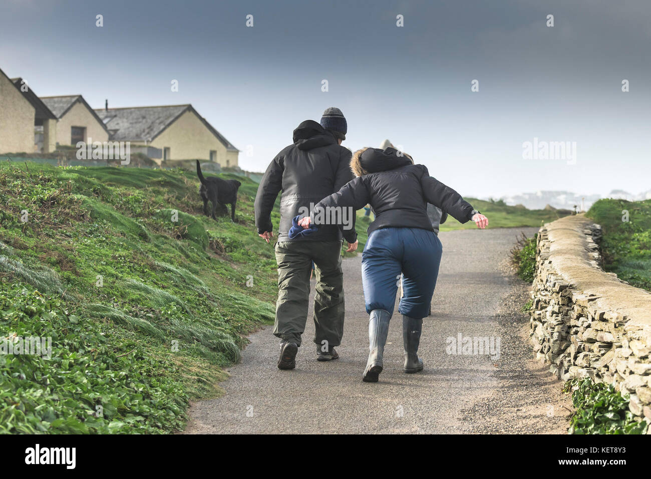 Météo britannique Brian Storm - un couple en train de marcher dans les vents de tempête stormforce comme Brian apporte sauvage météo à la côte nord des Cornouailles. Banque D'Images