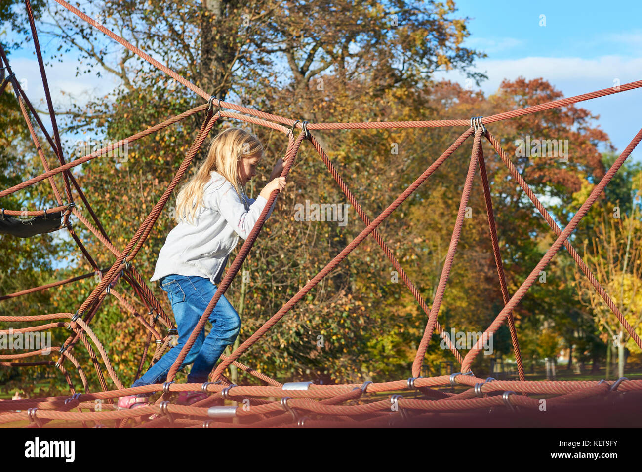 Jeune fille enfant active l'escalade spider web jeux pour enfants activité. les enfants Activités de plein air. Banque D'Images