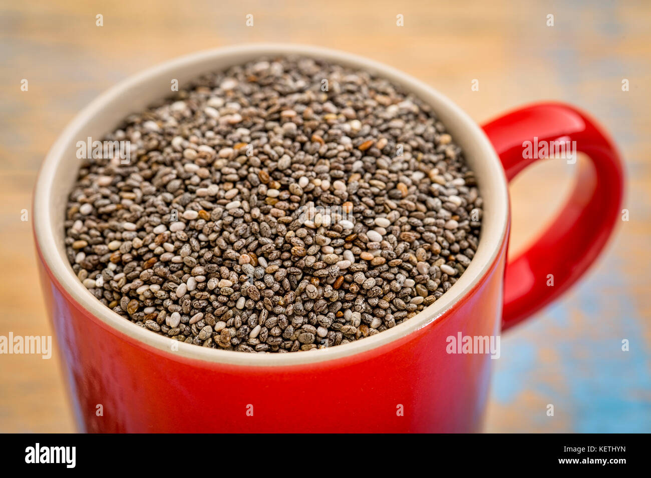 Les graines de chia noir dans une petite tasse à café en grès Banque D'Images