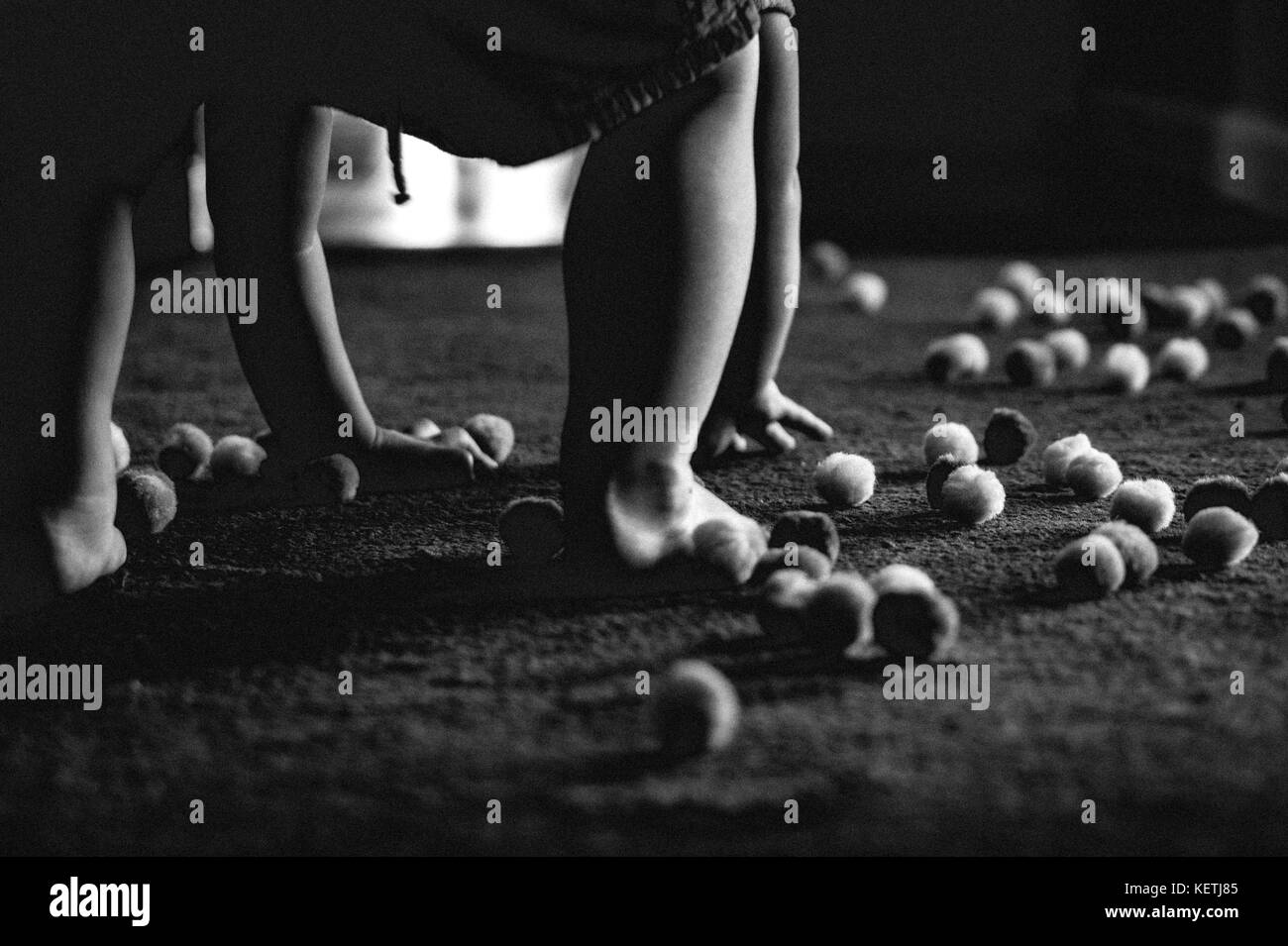 Mains et pieds de bébé parmi les pom-poms Banque D'Images