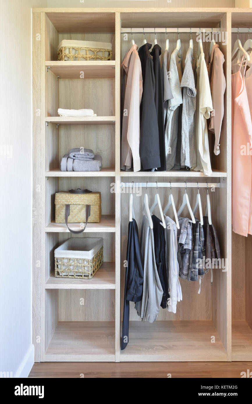 Penderie moderne avec rangée de vêtements accrochant dans armoire en bois  Photo Stock - Alamy