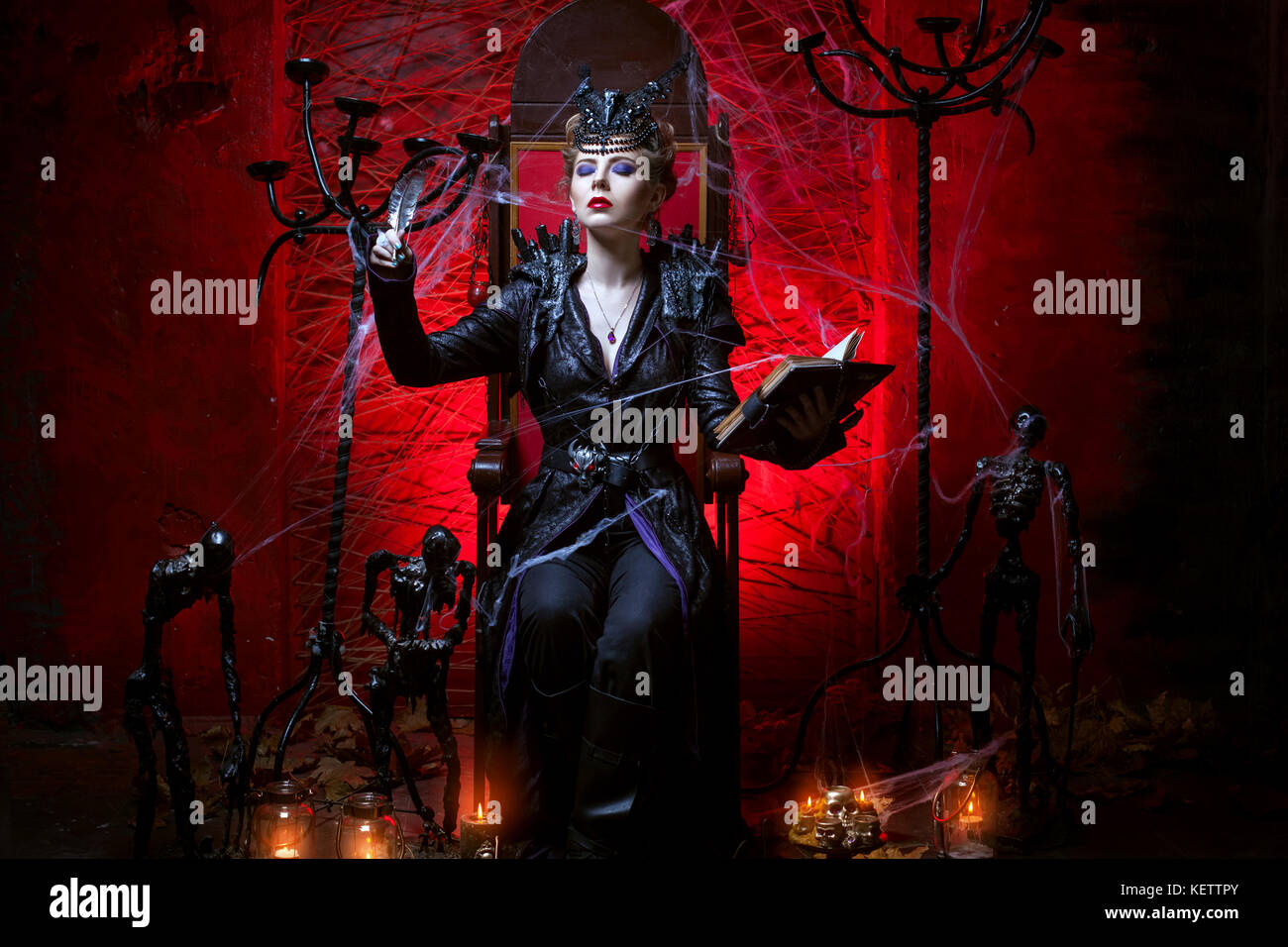 Une femme qui s'assied sur un trône dans une salle rouge et conjure Banque D'Images