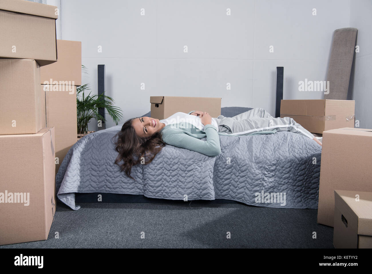 Woman lying on bed at home Banque D'Images