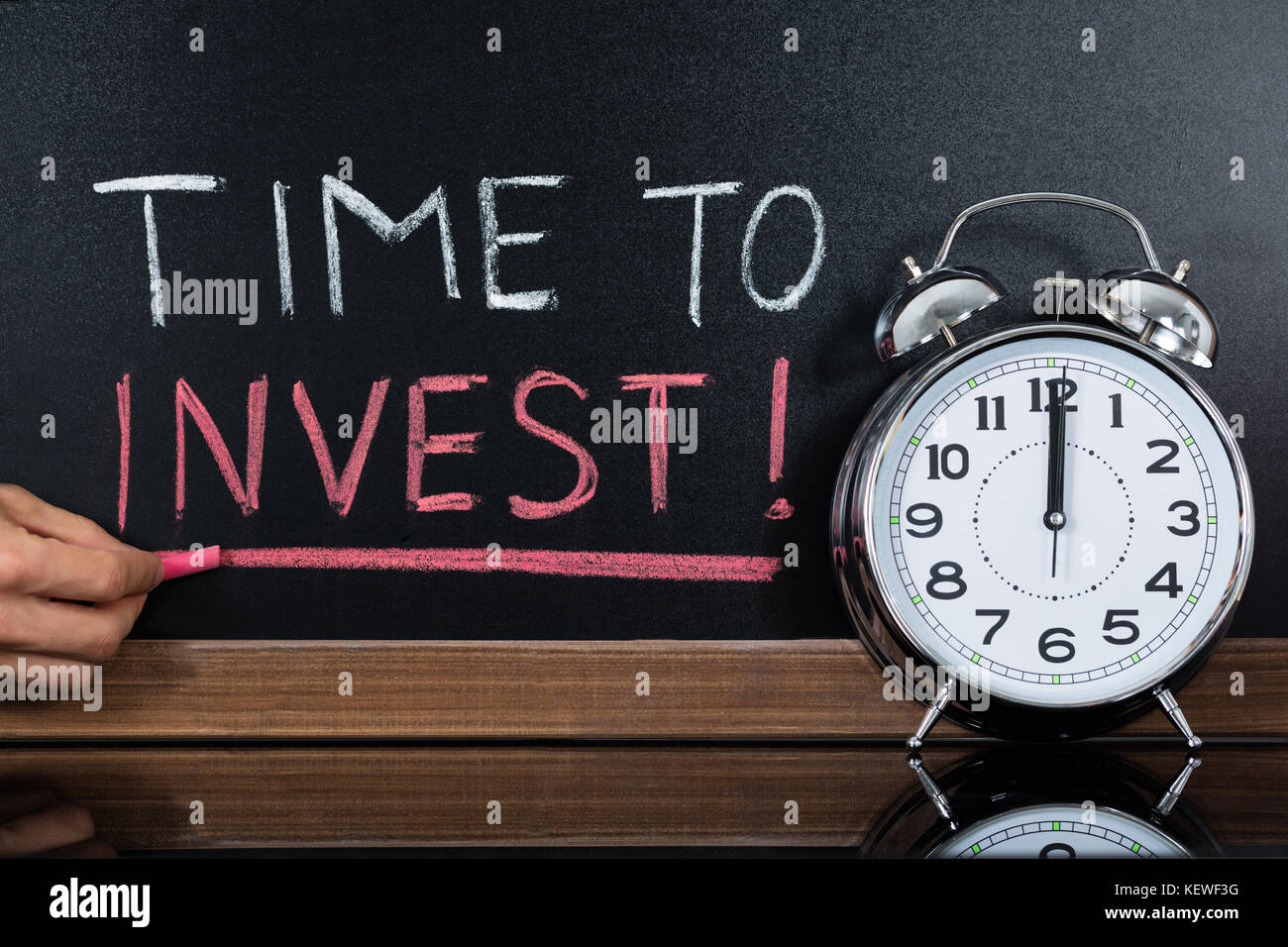 Chronomètre en face de temps à investir concept written on blackboard Banque D'Images