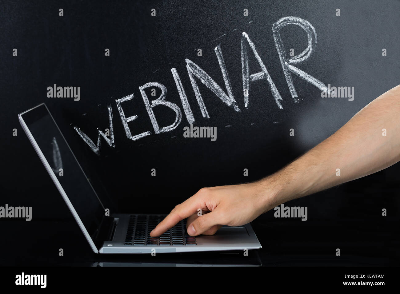 Close-up of a la main à l'aide d'ordinateur portable pour webinar sur le fond noir Banque D'Images