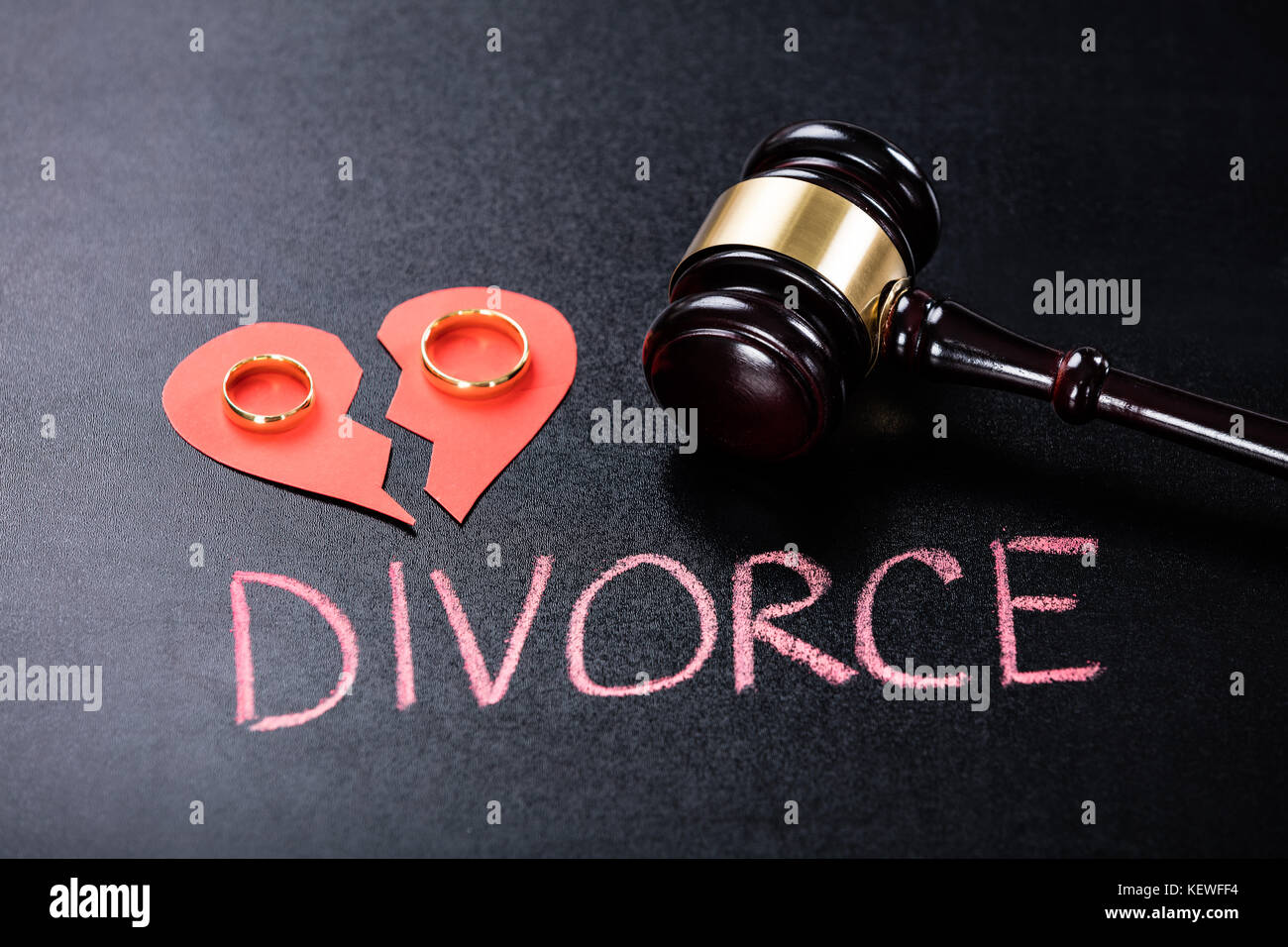 Close-up of divorce concept sur tableau noir avec anneau d'or sur rouge cœur brisé Banque D'Images