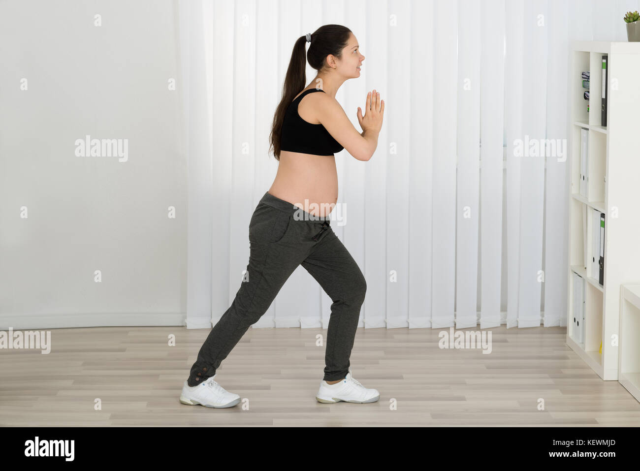 Photo de jeune femme enceinte l'exercice à la maison Banque D'Images
