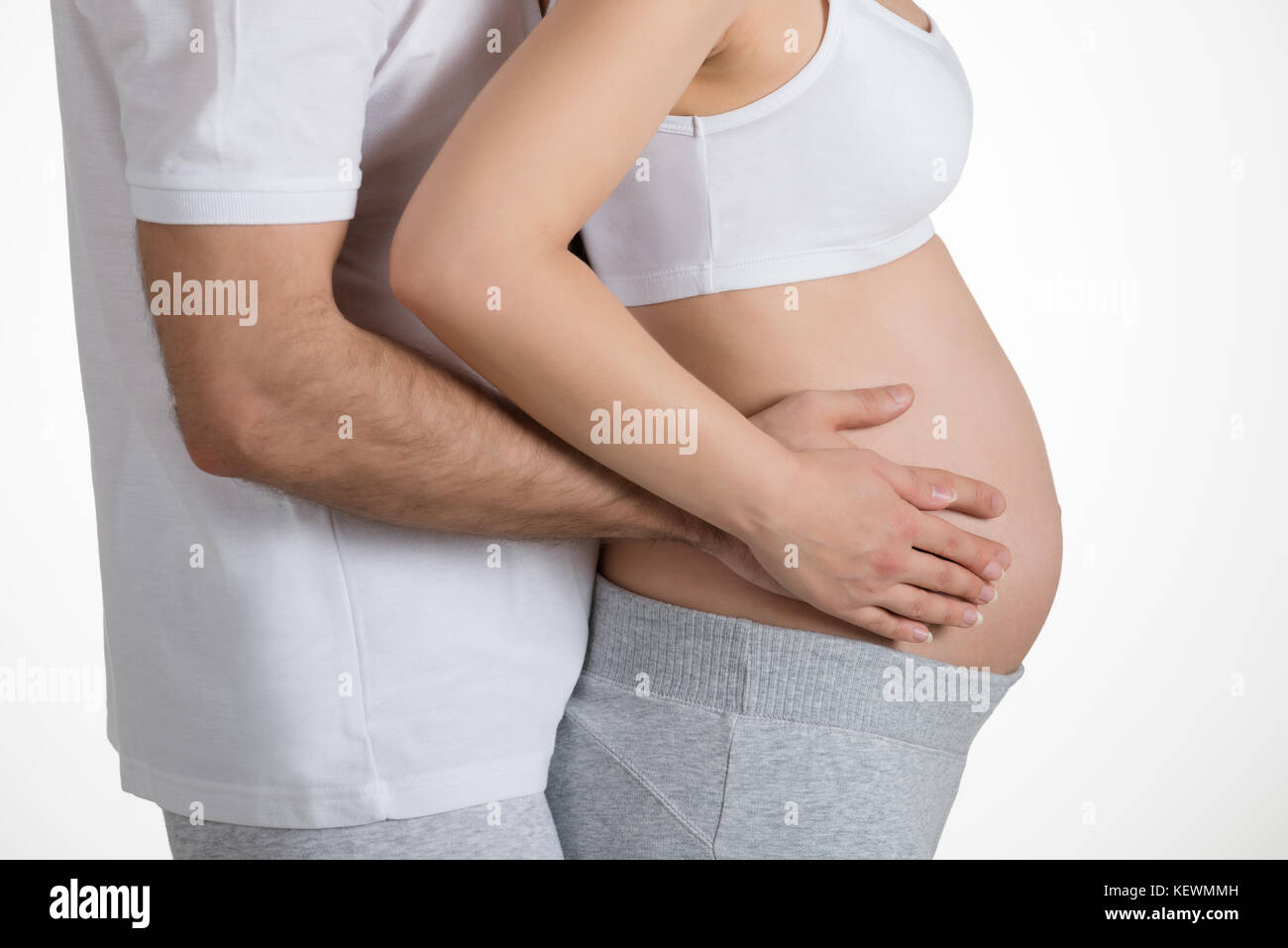 Mid section of young couple mains sur ventre Banque D'Images