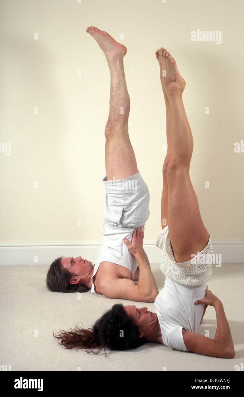 Jeune couple doing yoga épaules stand Banque D'Images
