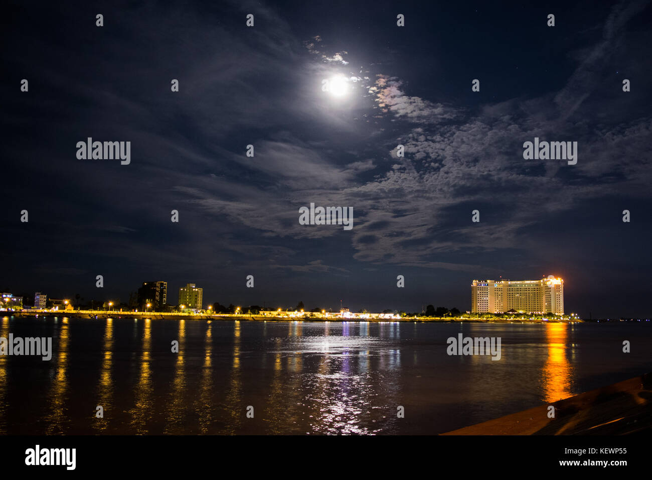 Nuit paysage de la rivière Tonle Sap et son conflux avec le Mékong. Hôtel de luxe dans la distance, la lune reflétant, Sisowath Quay, au Cambodge Banque D'Images