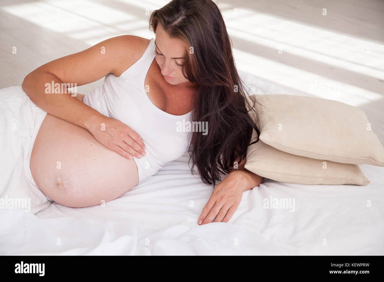 Une femme enceinte est au lit en attente de la naissance d'un enfant Banque D'Images