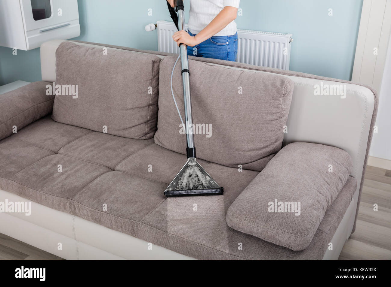 Nettoyage de canapé avec l'aspirateur à la maison Photo Stock - Alamy