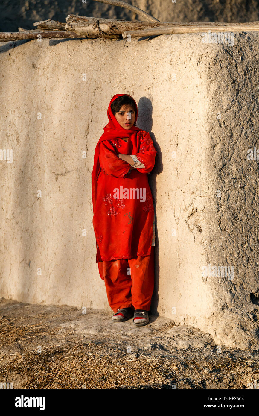 Une jeune Afghane dans un Panjabb rouge se trouve à l'extérieur un composé dans la province de Helmand, Afghanistan. Banque D'Images