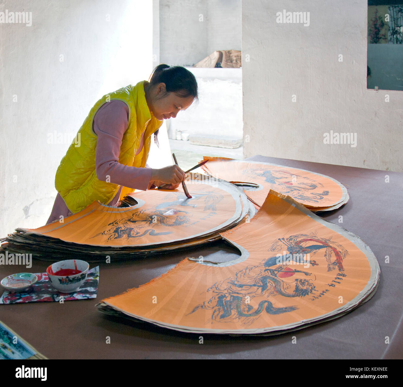 Femme peignant un grand fan chinois dans un atelier artisanal, Yangshuo, Guangxi, Chine Banque D'Images