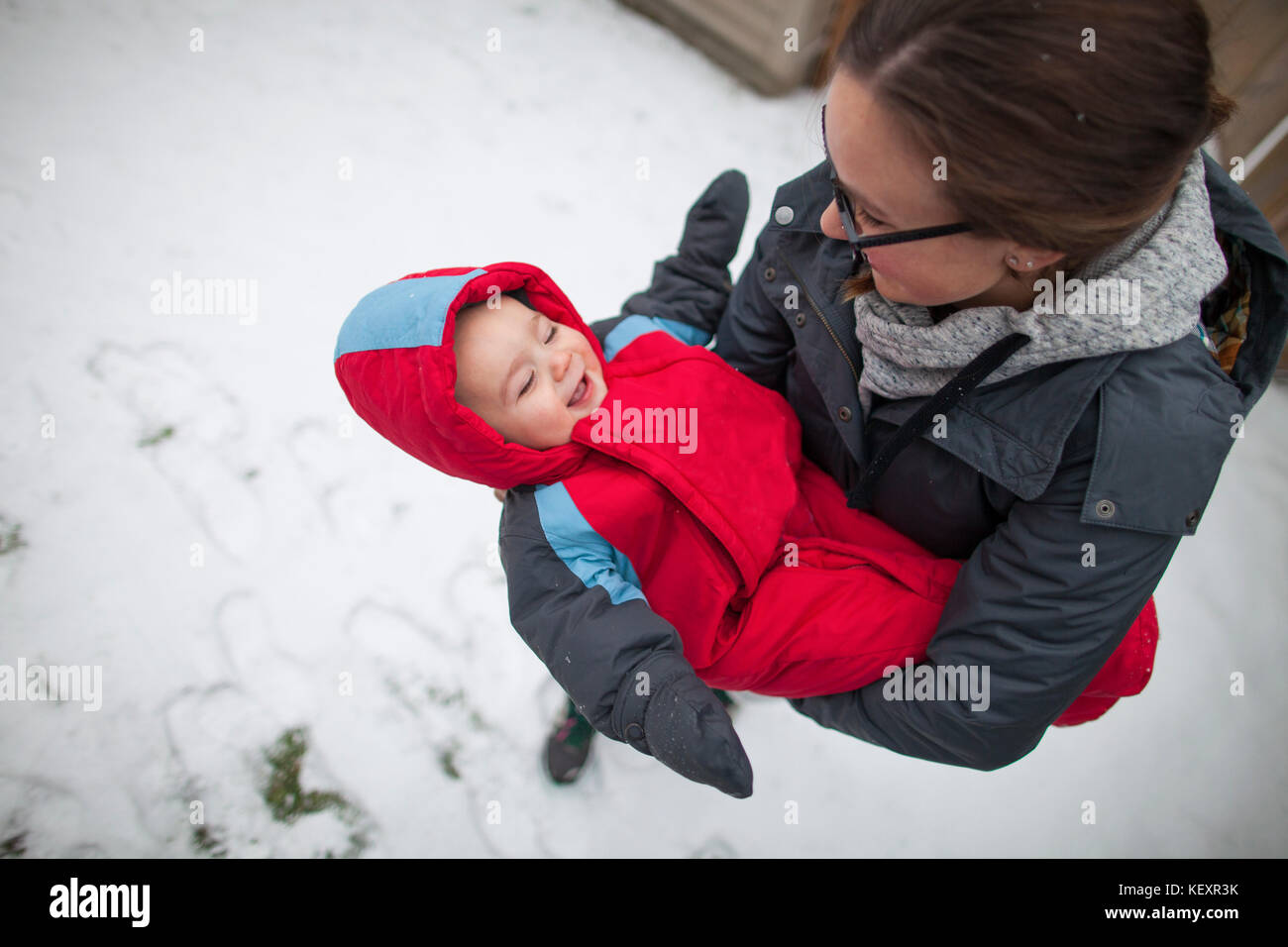 Mother holding laughing baby à l'extérieur en hiver tout en portant des vêtements chauds, Langley, Colombie-Britannique, Canada Banque D'Images