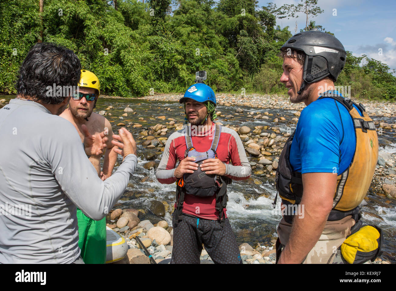 Photo d'hommes discutant briefing de sécurité avant le départ sur la rivière de la jungle expédition paddleboard stand-up, parc national de Manu, Pérou Banque D'Images