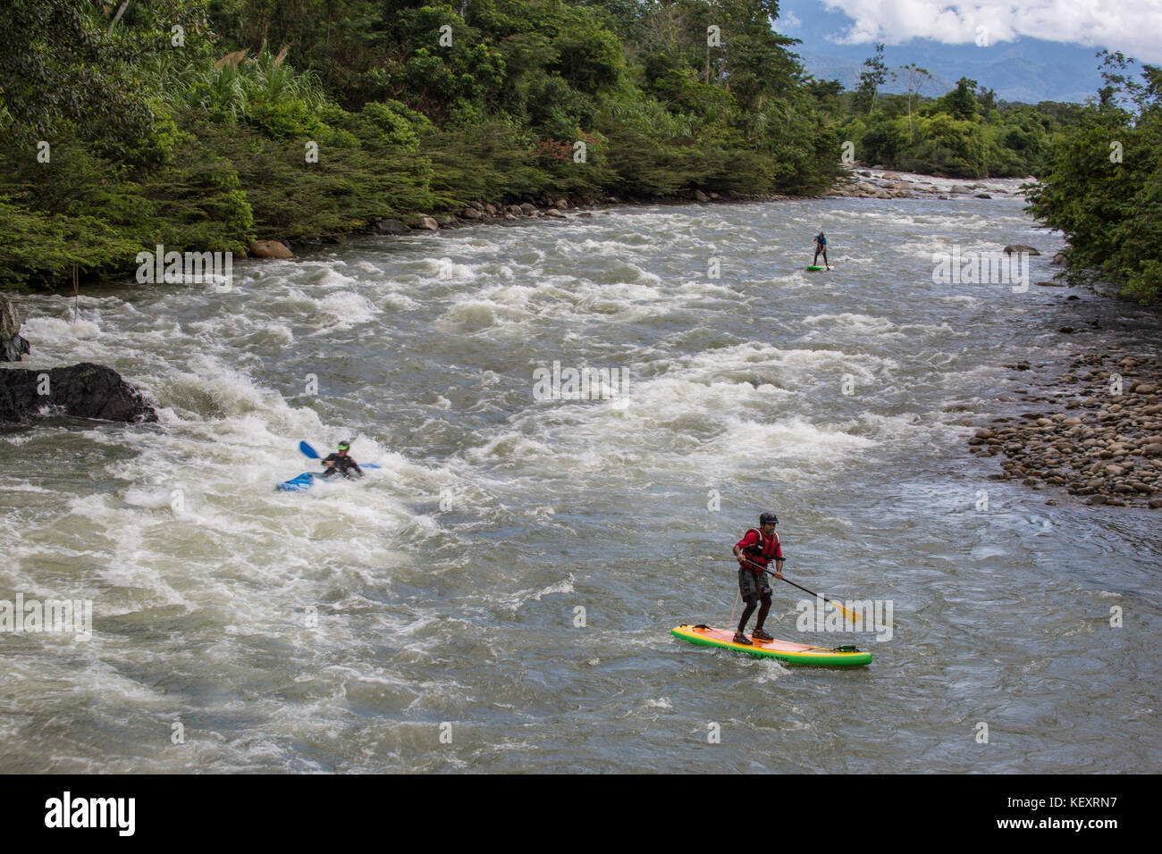 Les hommes de naviguer sur l'eau vive stand-up paddleboards et kayaks lors d'expédition de la rivière de la jungle en Amazonie péruvienne, le Pérou. Banque D'Images