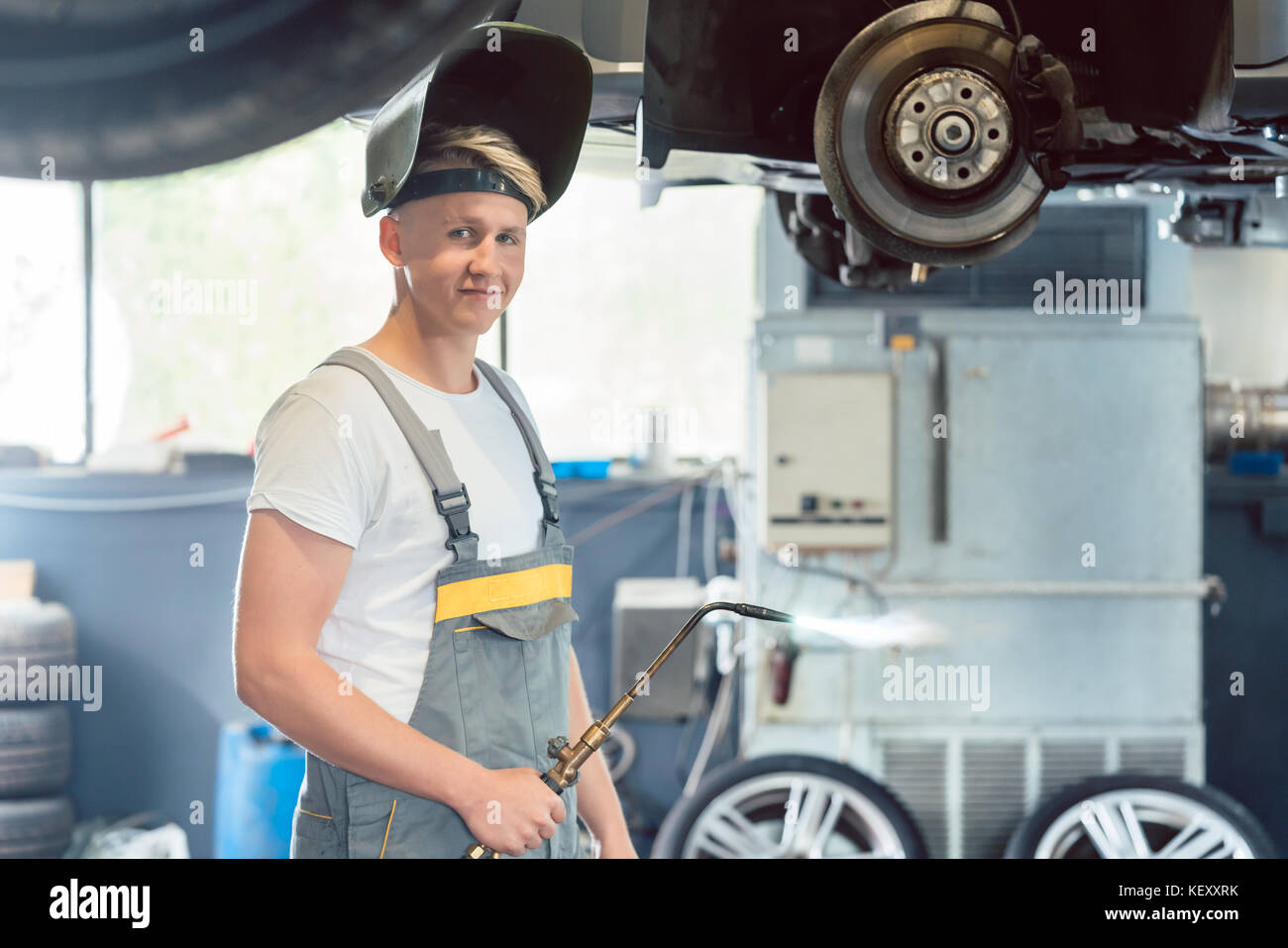 Portrait of a handsome auto mechanic looking at camera avec conf Banque D'Images