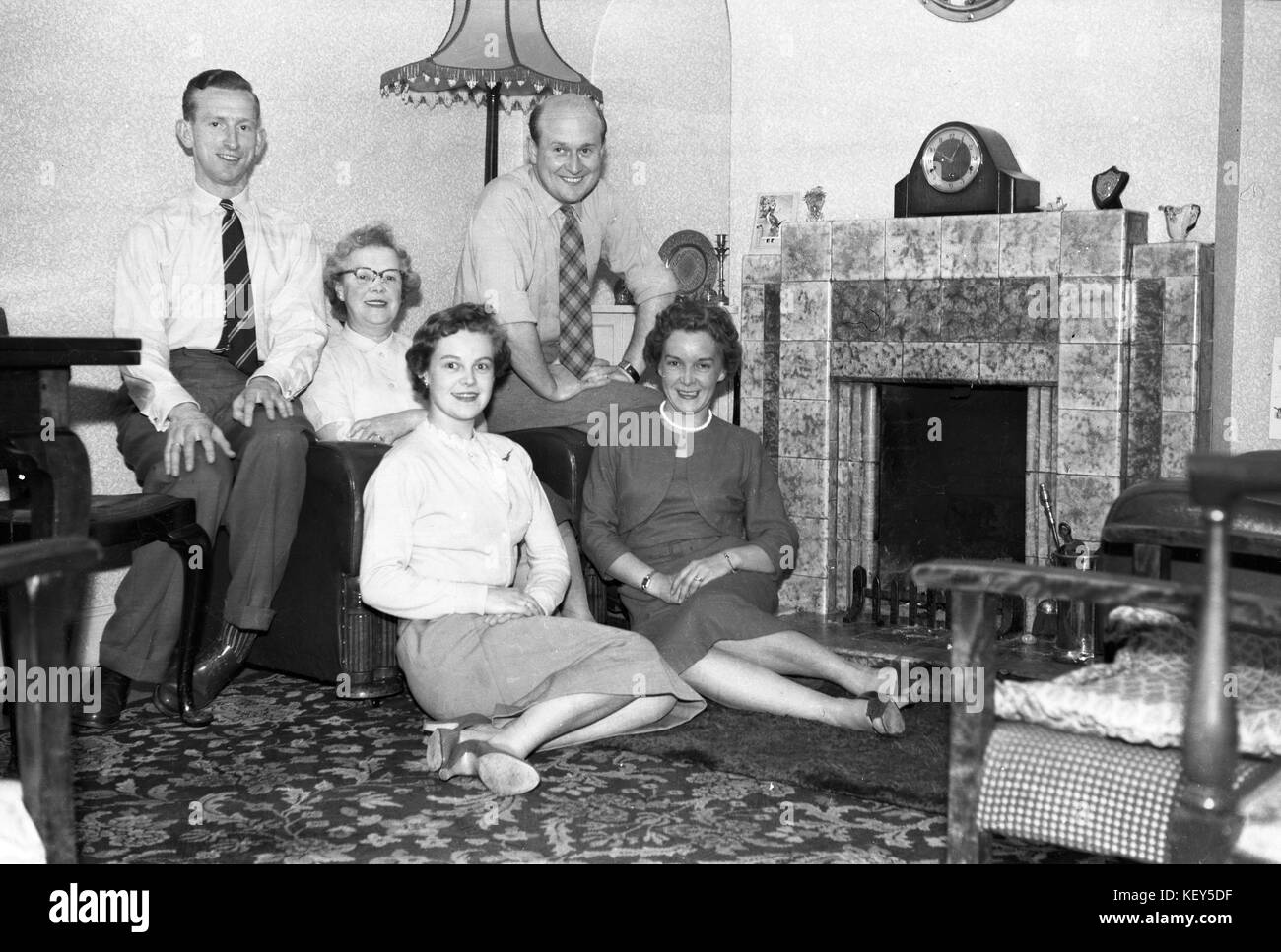 Pose de la famille dans un cadre typique dans le salon en face de la cheminée et du manteau c1955. photo par Tony henshaw Banque D'Images