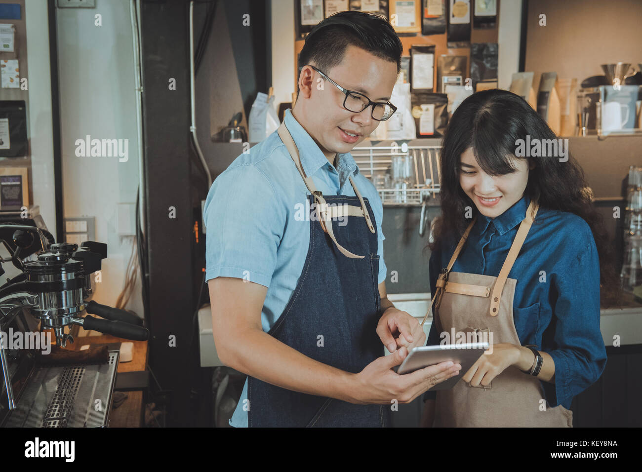 Deux des baristas asiatiques prendre une commande par digital tablet. café restaurant service, industrie alimentaire et des boissons concept. Banque D'Images