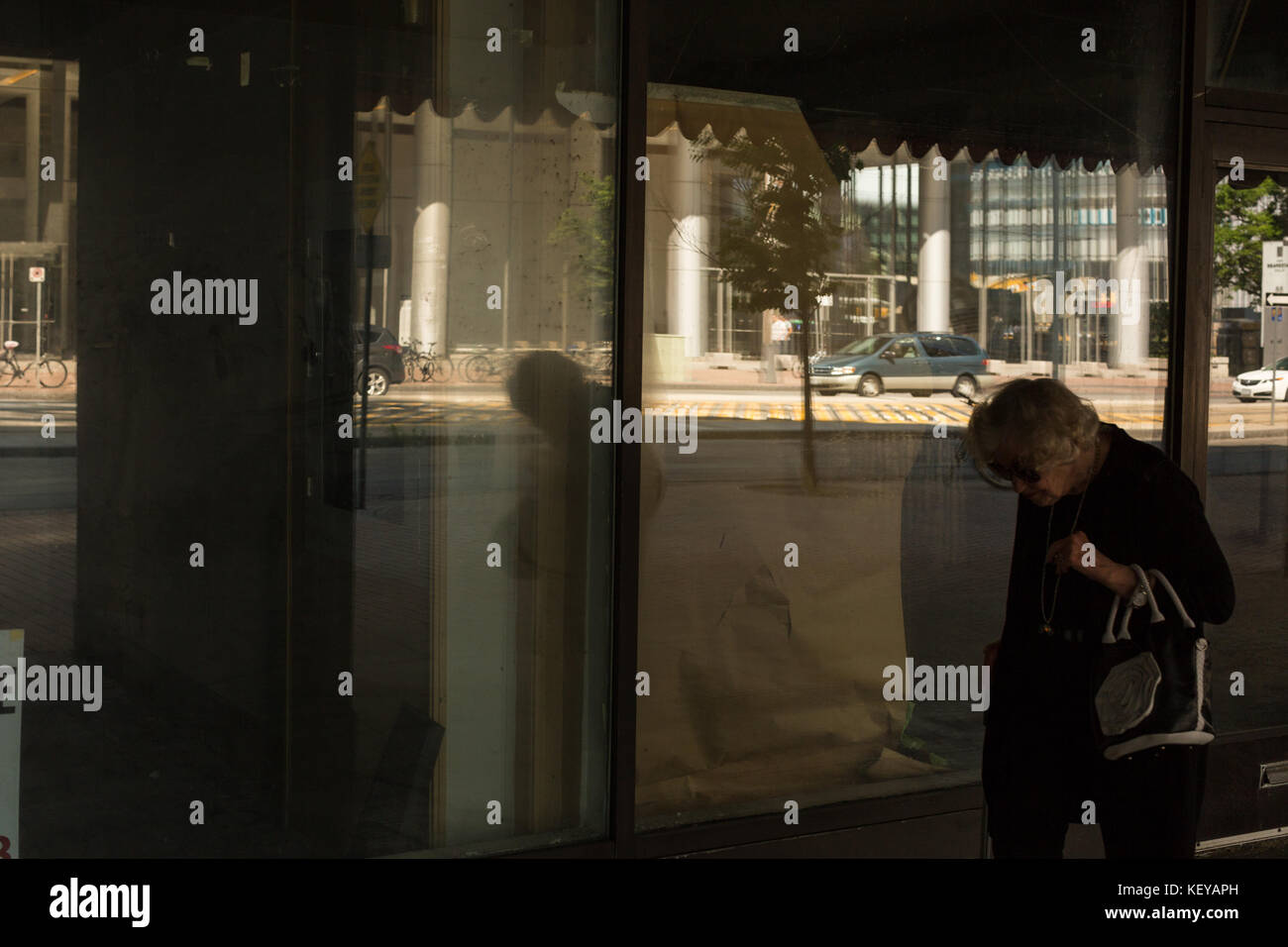 Très vieille dame à pied par une vitrine dans le centre-ville de Toronto, Canada Banque D'Images