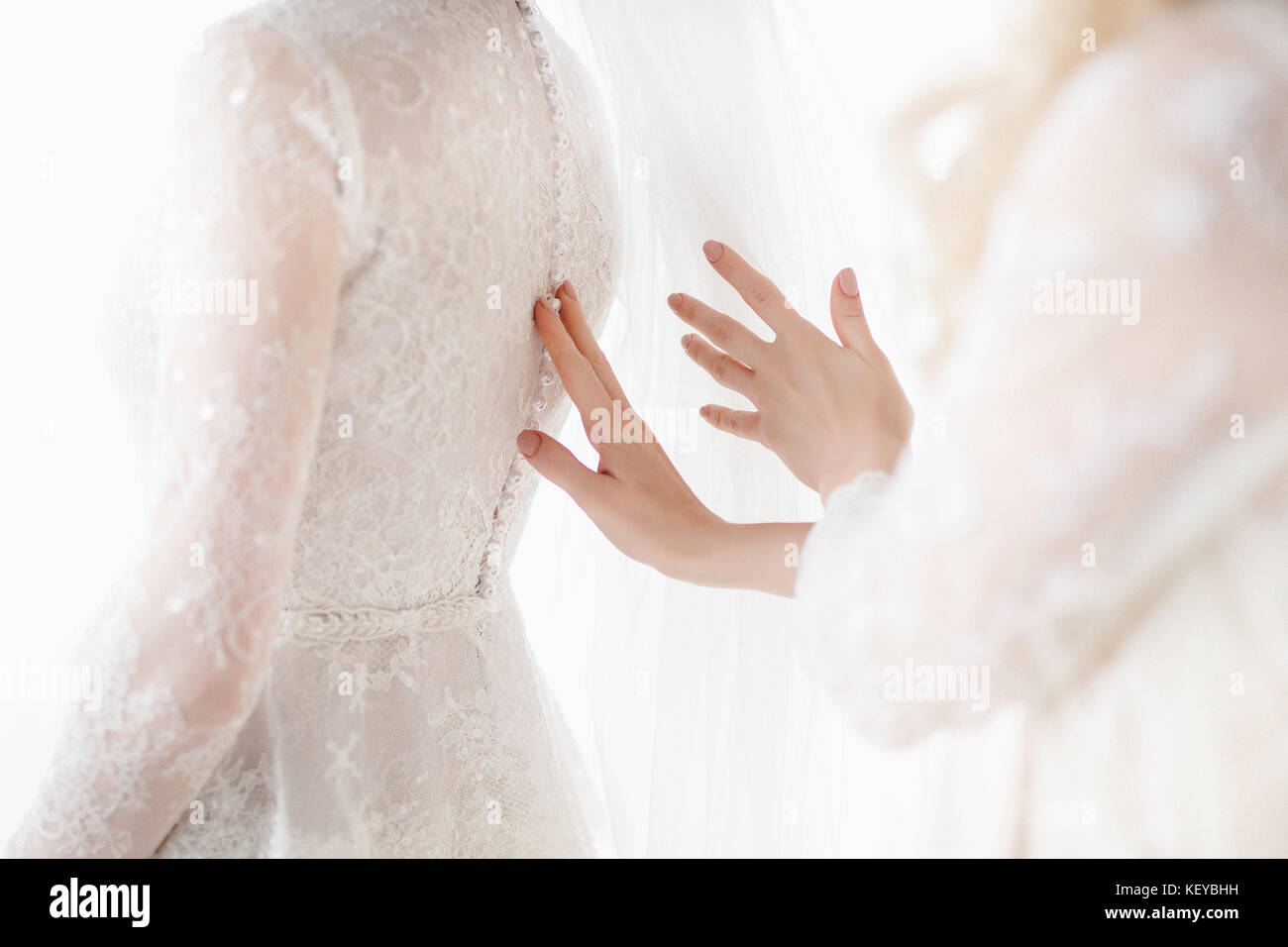 Mariée de demoiselle d'honneur de la préparation pour le jour du mariage, aider fixer sa robe. Détails de mariage Banque D'Images